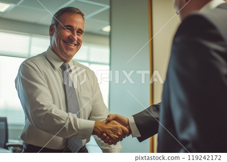 Smiling businessman shaking hands with a colleague Smiling businessman shaking hands with a colleague 119242172