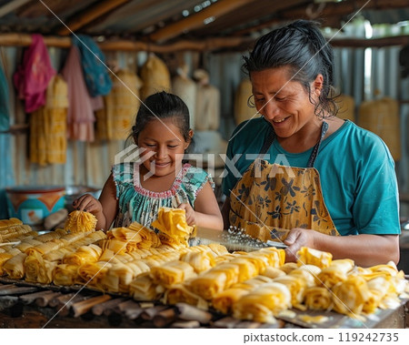 A family making tamales together in a kitchen. 119242735