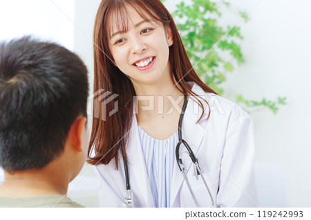 A young woman in a white coat examining a child A young woman in a white coat examining a child 119242993