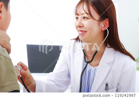 一名身穿白大褂的年輕女子正在檢查孩子 119242997