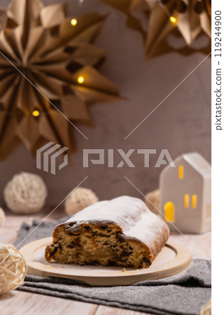 Traditional German Christmas stollen cake in background of handmade festive decor. Winter holiday treats. Vegan baking recipe 119244900