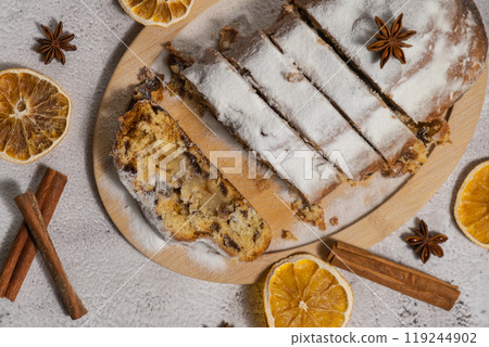 Slices of Homemade Christmas traditional cake pie with marzipan nuts and dried fruits pastry dessert stollen. Winter holidays season atmosphere. Delicious tasty composition home table setting Slices of Homemade Christmas traditional cake pie with marzipan nuts and dried fruits pastry dessert stollen. Winter holidays season atmosphere. Delicious tasty composition home table setting 119244902