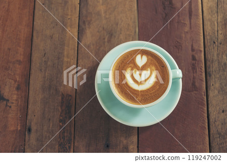 Latte art coffee cup with milk on wooden table. Espresso shot make latte art hot coffee cup. Cappuccino with milk in italian coffee shop cafe. Brown hot caffeine beverage in cafeteria with copy space 119247002