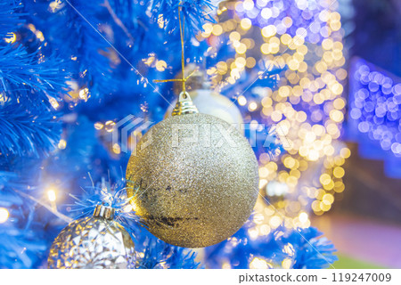 Golden Christmas Ornament sparkling blurred background. Golden glitter shiny illuminated Christmas Lights banner. Happy Holidays background for template on christmas card Gold bokeh presentation. 119247009