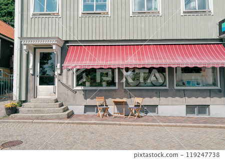 The exterior of a cafe with a red awning The exterior of a cafe with a red awning 119247738