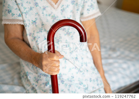 Asian elderly disability woman holding waling stick, wood cane, round handle, walking aid for help to walk. Asian elderly disability woman holding waling stick, wood cane, round handle, walking aid for help to walk. 119247762