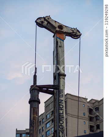 heavy construction gear (pile driver) in operation in front of a residual building 119249298