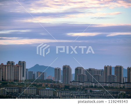Chongqing city view in sunset, high rise buildings on hills and mountain in the background 119249343