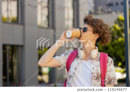 Smiling man tourist enjoying morning coffee hot drink relaxing, taking a break on urban city street 119249877