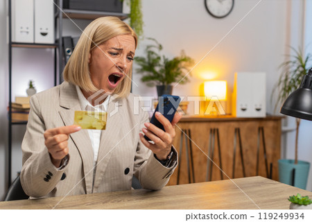 Angry mad stressed businesswoman trying to pay online shopping with blocked credit card smartphone Angry mad stressed businesswoman trying to pay online shopping with blocked credit card smartphone 119249934