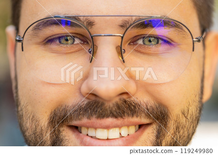 Closeup macro portrait of natural young attractive man in glasses with gray eyes looking at camera 119249980