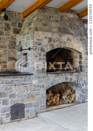 Stone restaurant barbecue firewood, open brick oven cooking food dishes on fire indoors in backyard Stone restaurant barbecue firewood, open brick oven cooking food dishes on fire indoors in backyard 119250019