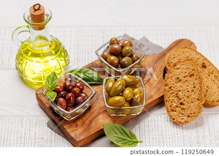 An assortment of various olives presented in a bowl, showcasing different colors, textures, and flavors An assortment of various olives presented in a bowl, showcasing different colors, textures, and flavors 119250649