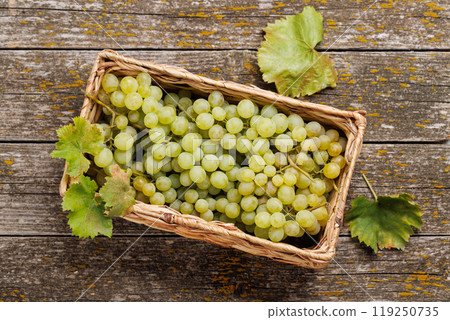 A wicker basket brimming with grapes 119250735