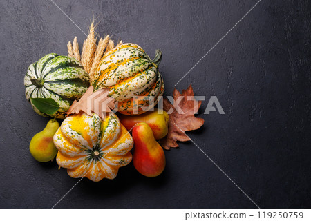 Autumn-themed food arrangement with pumpkins, pears, and autumn leaves 119250759