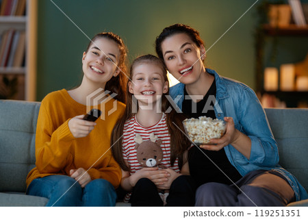 family watching  TV in the evening at home 119251351