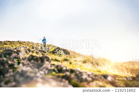 Male runner jogging down the hill on dirt running trail. Morning running training for young man. Male runner jogging down the hill on dirt running trail. Morning running training for young man. 119251602