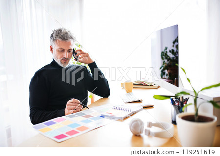 Homeoffice for handsome man. Man working in his office in home, making phone call. Telecommuting. Homeoffice for handsome man. Man working in his office in home, making phone call. Telecommuting. 119251619