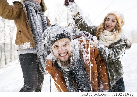 Friends in snowball fight in snowy nature, throwing snow and having fun. First snowfall of the season. Friends in snowball fight in snowy nature, throwing snow and having fun. First snowfall of the season. 119251652