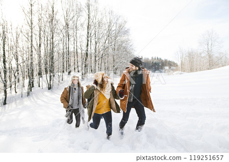 Friends in snowball fight, running and catching each other in snowy nature. First snowfall of the season. Friends in snowball fight, running and catching each other in snowy nature. First snowfall of the season. 119251657