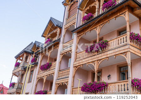 Petunia flowers on the balcony of a wooden house. 119252043