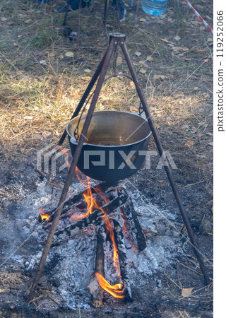 Cooking food over a fire. Cauldron fire outdoor. Cooking food over a fire. Cauldron fire outdoor. 119252066