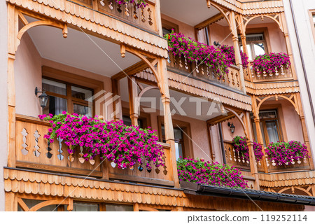 Petunia flowers on the balcony of a wooden house. 119252114
