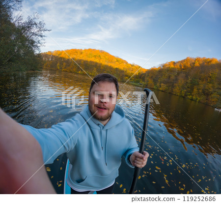 Man on Paddleboard Surrounded by Autumn Colors Man on Paddleboard Surrounded by Autumn Colors 119252686