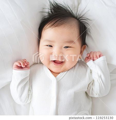 A top-down photo of a baby lying on a bed 119253130