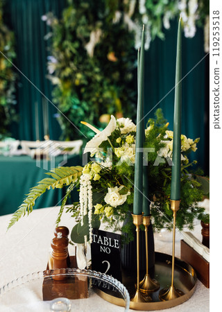 Luxurious restaurant. Luxurious interior, white tables, serving dishes and glasses for guests. Green decor 119253518