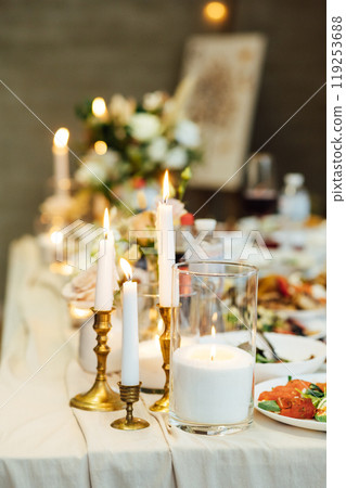 Elegant neutral coloured wedding table scape with flowers and candles 119253688