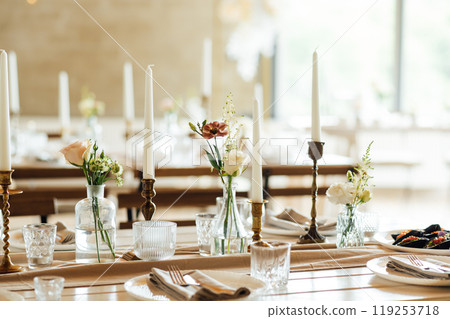Elegant neutral coloured wedding table scape with flowers and candles 119253718