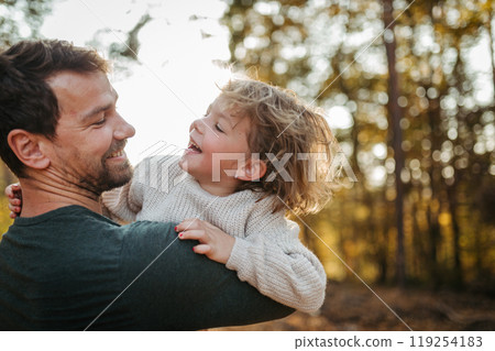 Father and girl during walk in autumn forest. Dad and girl having fun outdoors. 119254183