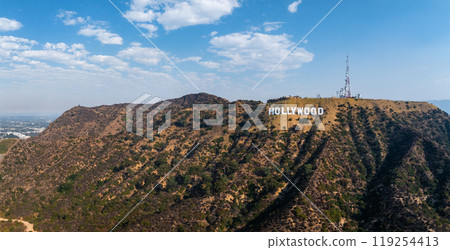 The Hollywood Sign is prominently displayed on the hills of the Santa Monica Mountains, surrounded by rugged terrain and sparse vegetation under a clear sky. The Hollywood Sign is prominently displayed on the hills of the Santa Monica Mountains, surrounded by rugged terrain and sparse vegetation under a clear sky. 119254413