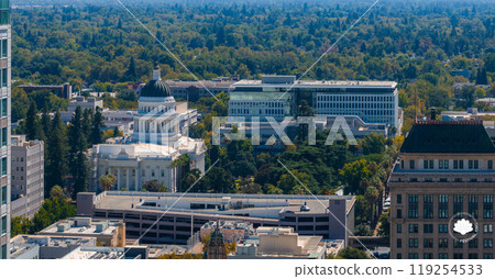 Aerial view of Sacramento highlighting the California State Capitol with its white dome, surrounded by greenery and urban structures, extending to a lush horizon. Aerial view of Sacramento highlighting the California State Capitol with its white dome, surrounded by greenery and urban structures, extending to a lush horizon. 119254533