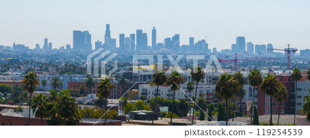 The image features Los Angeles skyline with downtown skyscrapers, residential and commercial buildings, palm trees, and construction cranes under a clear blue sky. The image features Los Angeles skyline with downtown skyscrapers, residential and commercial buildings, palm trees, and construction cranes under a clear blue sky. 119254539