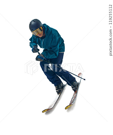 Skier shifts weight, carving through snow with grace and power. His yellow goggles and blue outfit contrast against white studio background. 119255112