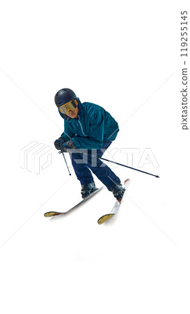 In full motion, skier leans into slope, poles angled for control against white studio background. Determination in his stance shows his dedication to sport. 119255145
