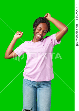 A young woman with braids expresses excitement with a clenched fist against a bright green background A young woman with braids expresses excitement with a clenched fist against a bright green background 119255908