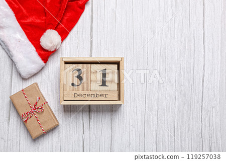 christmas hat, gift and wooden calendar 31 december on a wooden background 119257038