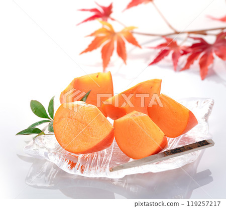 Taste of autumn: Persimmons served on a transparent plate (white background) Taste of autumn: Persimmons served on a transparent plate (white background) 119257217