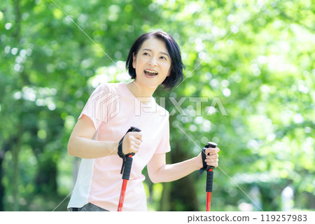 Middle-aged woman doing Nordic walking 119257983