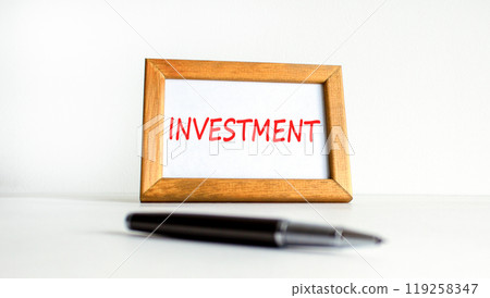 Investment symbol. Concept word Investment on beautiful wooden picture frame. Beautiful white background. Black pen. Business investment concept. Copy space. Investment symbol. Concept word Investment on beautiful wooden picture frame. Beautiful white background. Black pen. Business investment concept. Copy space. 119258347
