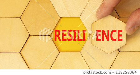 Resilience symbol. Concept word Resilience on beautiful wooden puzzles. Beautiful yellow background. Businessman hand. Business resilience concept. Copy space. 119258364