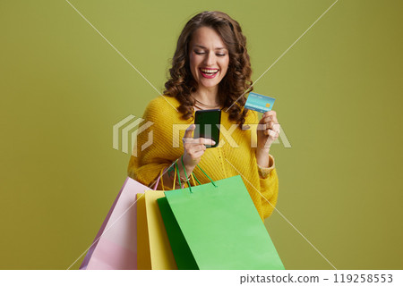 happy modern woman using smartphone isolated on green 119258553