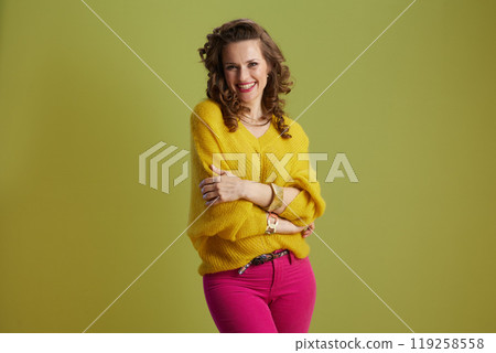 happy fit woman in yellow sweater isolated on green background 119258558
