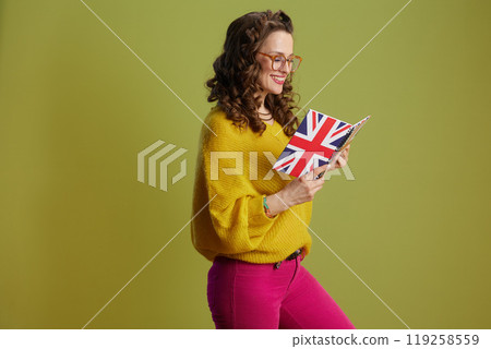 happy trendy female in sweater and glasses isolated on green happy trendy female in sweater and glasses isolated on green 119258559