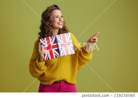 smiling fit female in yellow sweater isolated on green 119258560