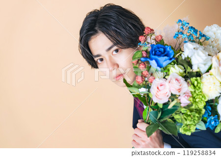一個穿著西裝的男人拿著一束鮮花 一個穿著西裝的男人拿著一束鮮花 119258834