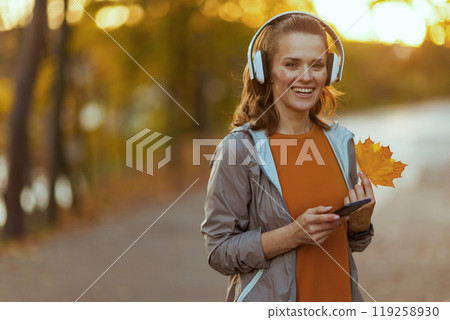 Portrait of happy trendy female in fitness clothes in park 119258930
